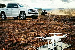 amarok blanca junto a un drone preparado para filmacion