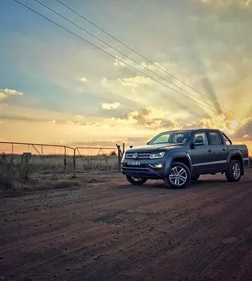 Camioneta Amarok en camino de tierra al atardecer