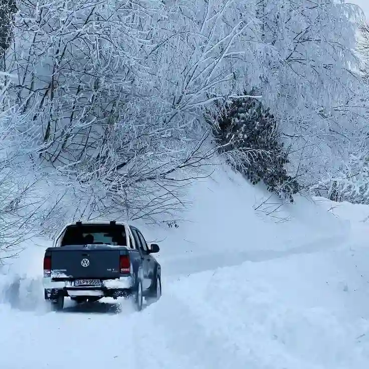 Camioneta conduciendo en la nieve cerca de una curva