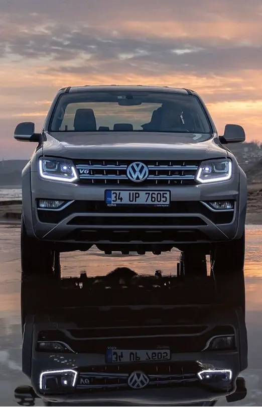 Camioneta Amarok sobre camino con poca agua que se ve reflejada
