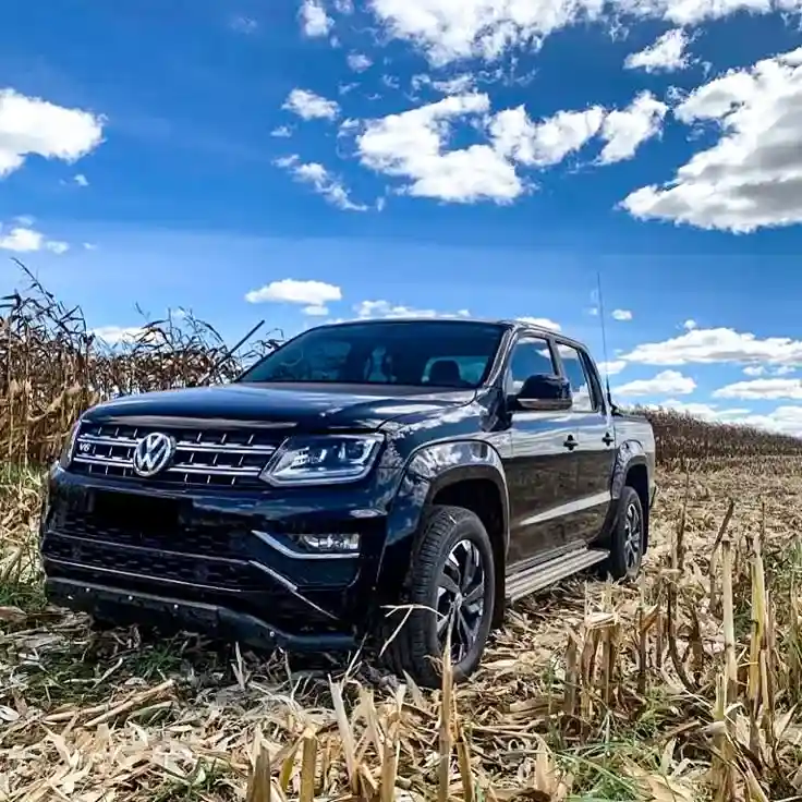 Camioneta Amarok color negro en un campo de maizales