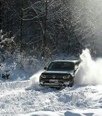 Camioneta Amarok conduciendo por camino con mucha nieve